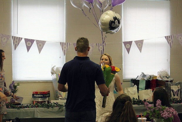 groom bringing bride surprise flowers at bridal shower