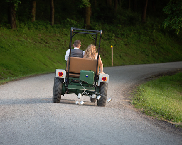 Bride and groom driving away in a tractor