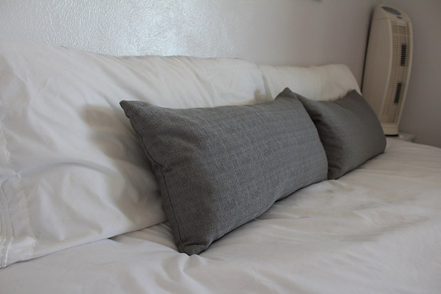 Gray throw pillows on white bed