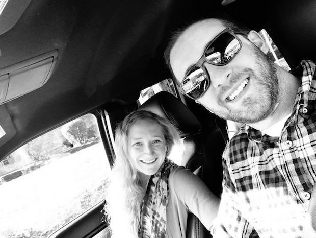 Husband and wife black and white picture smiling in car