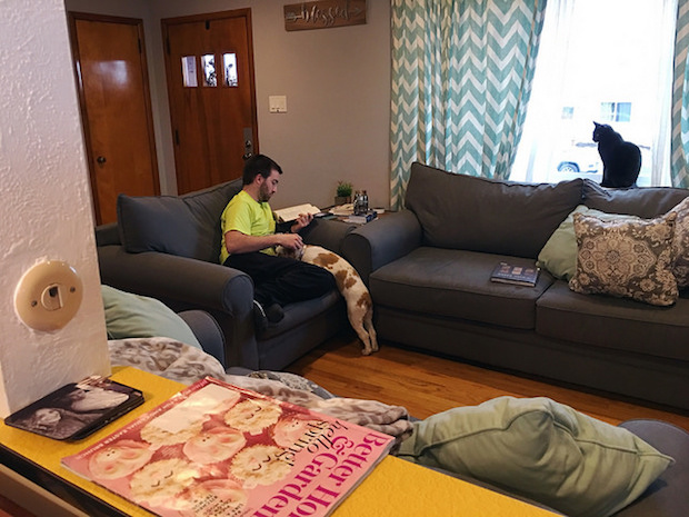 Guy reading with cocker spaniel puppy