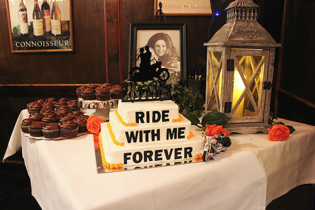 Harley Davidson Wedding Cake that says ride with me forever with motorcycle wedding cake topper and orange and black