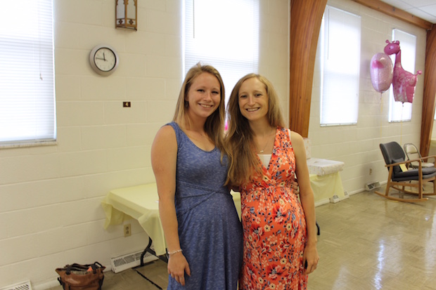 Sisters smiling at baby shower