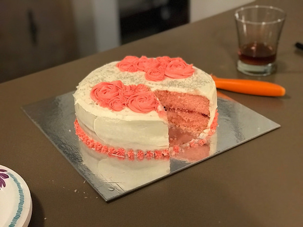 Strawberry cake with vanilla buttercream decorated with roses and sprinkles