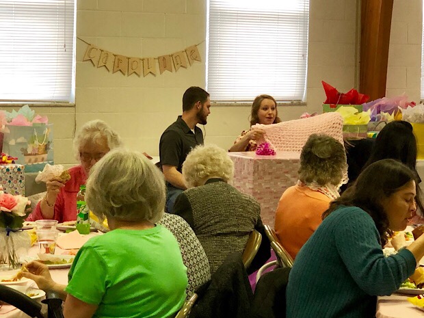 Husband and wife opening gifts at baby shower