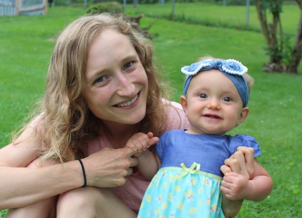Mother and baby girl smiling in grass