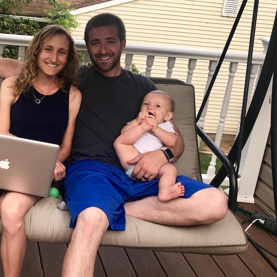 Family with baby girl putting toes in her mouth