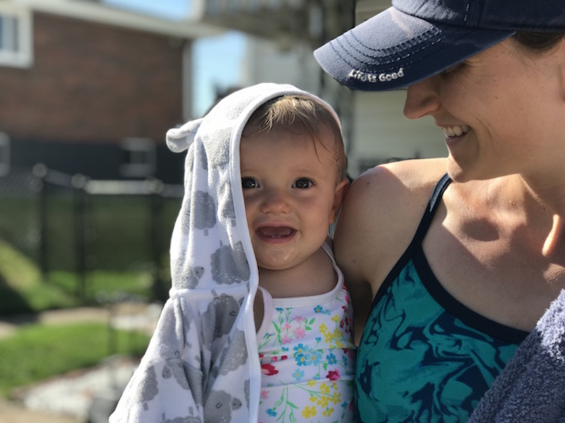 Baby girl smiling after swimming with hooded towel