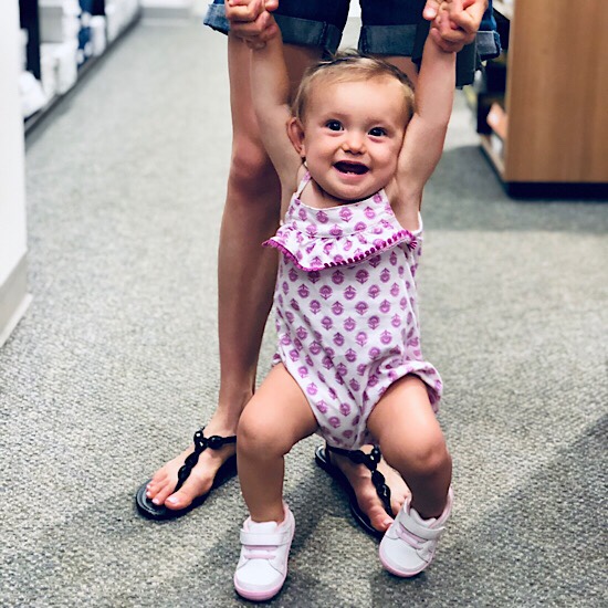 Baby girl smiling in shoe store