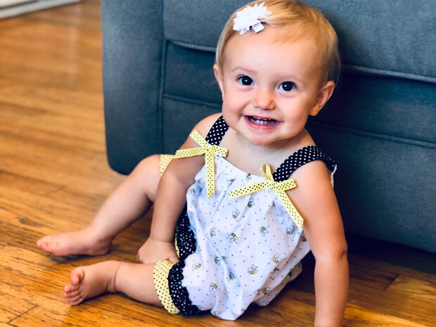 Baby smiling in bumble bee dress