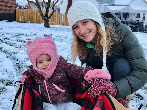 Mom and baby with sled in the snow