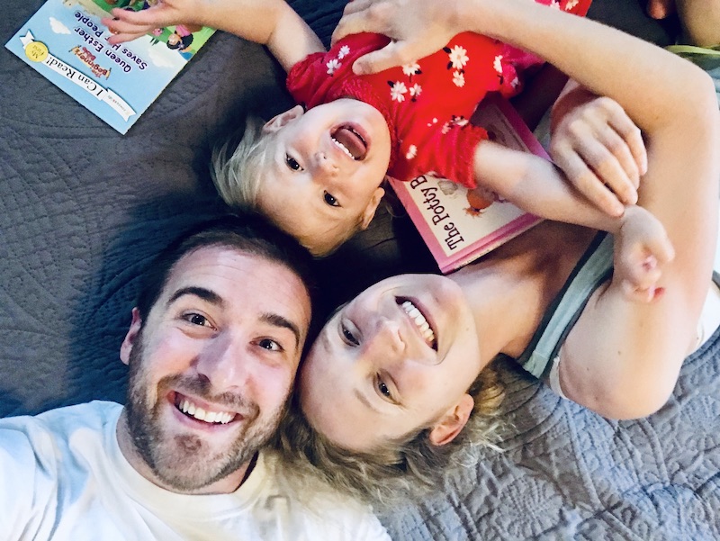 Family laying on bed smiling