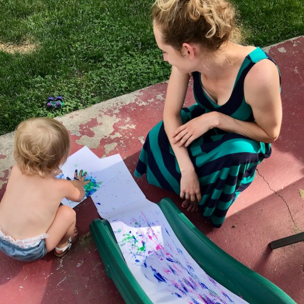 Toddler playing with paint on slide