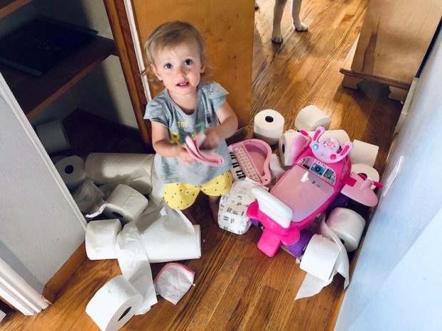 Toddler playing with toilet paper