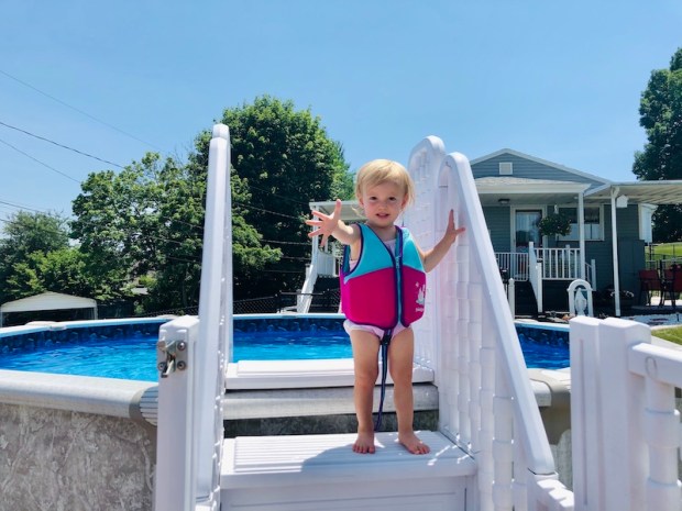 Toddler in life jacket by pool