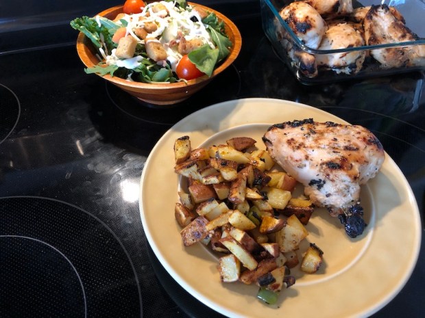 Chicken, fried potatoes, and salad