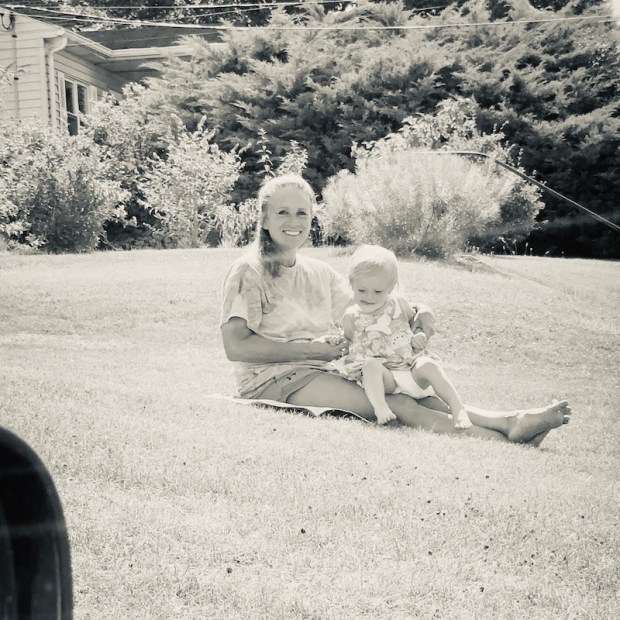 Grandma and toddler sitting in grass