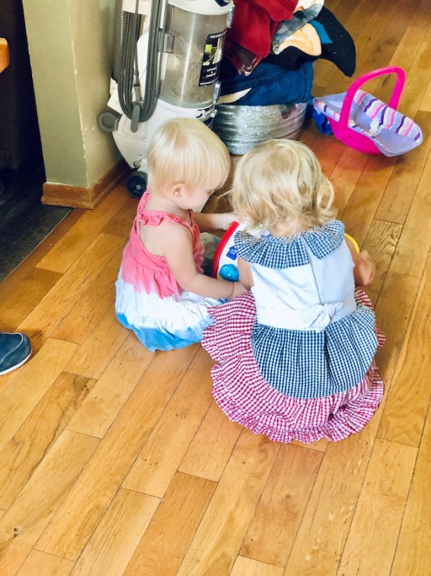 Toddlers in red white and blue dresses playing together
