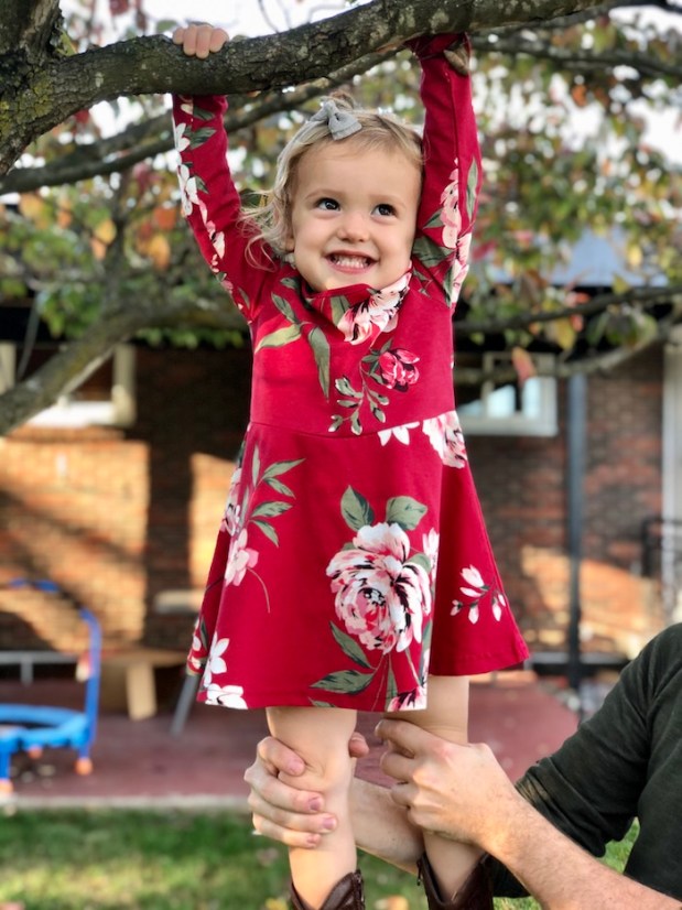 Toddler hanging in tree