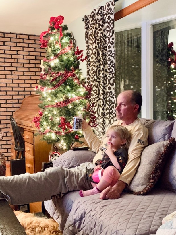 Grandpa with toddler at Christmas with tree 