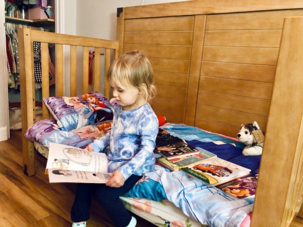Toddler reading on her bed