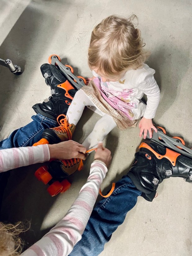 Toddler putting on roller skates