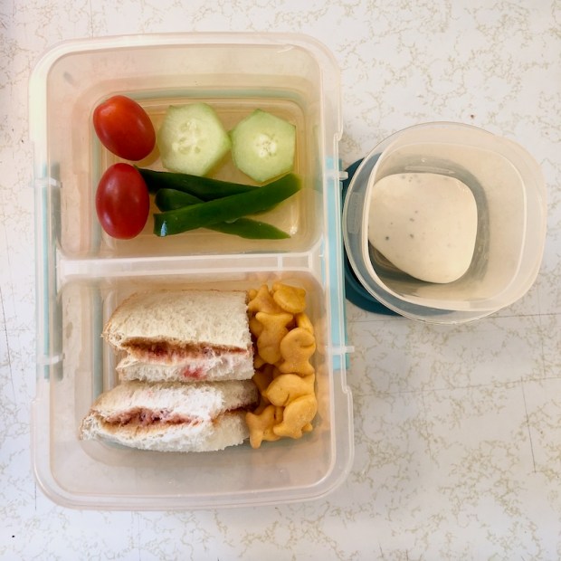 Toddler lunch of peanut butter and jelly, Goldfish, and vegetables with dip