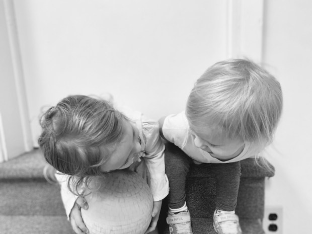Black and white photo of toddler girls looking at each other