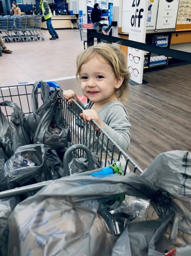 Toddler standing on cart at Walmart