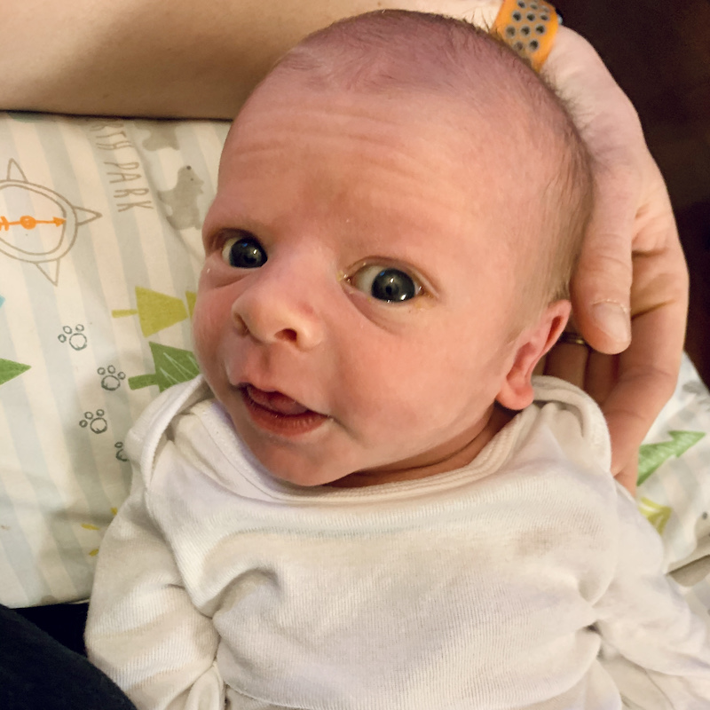 Newborn baby boy in white onesie
