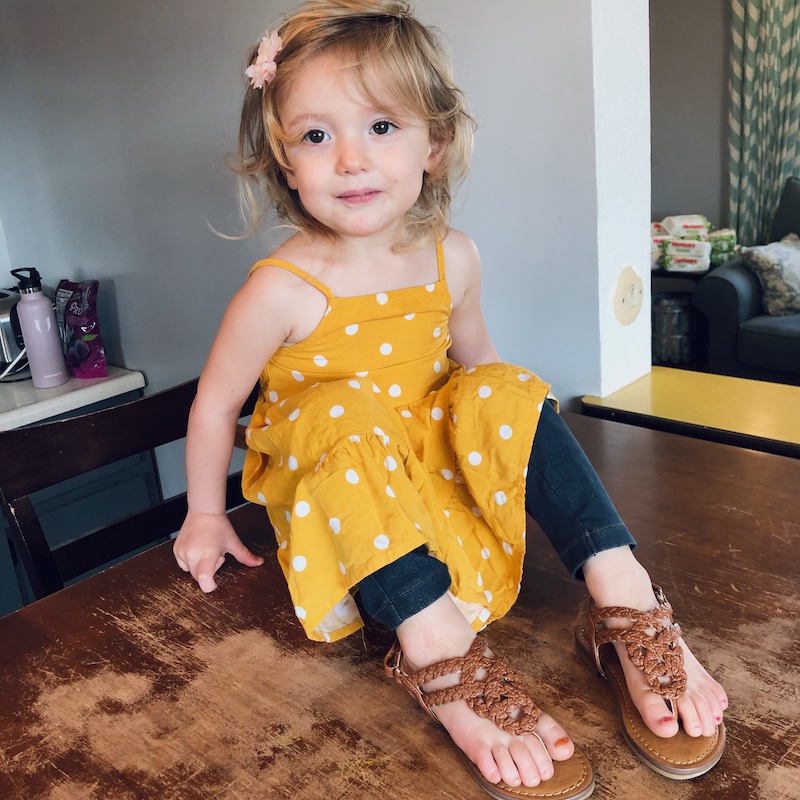 Toddler girl wearing sandals and yellow polka dot dress from Old Navy