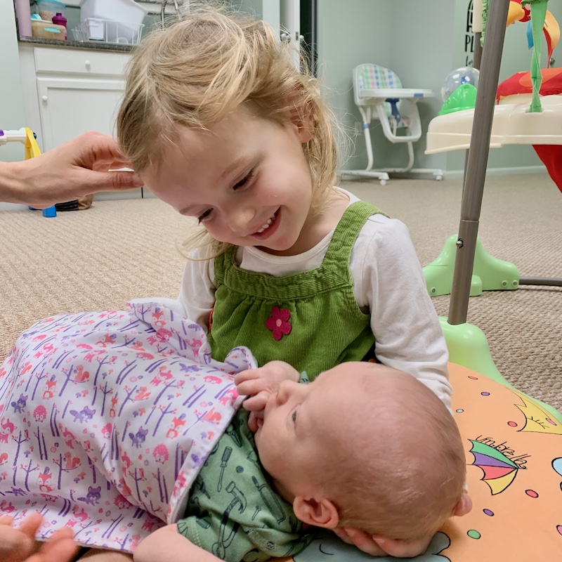 Toddler girl holding baby boy