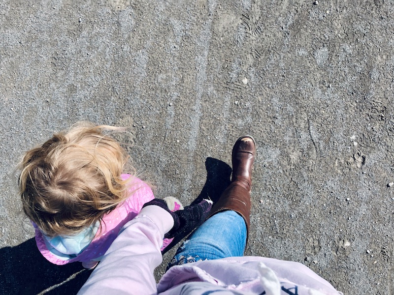 Mom holding daughters hand while walking on a trail