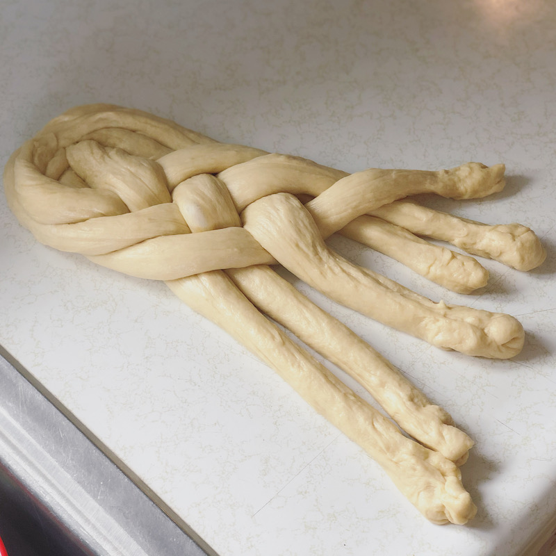 Six strand challah bread being braided 