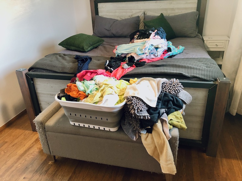 Piles of clean laundry on bed