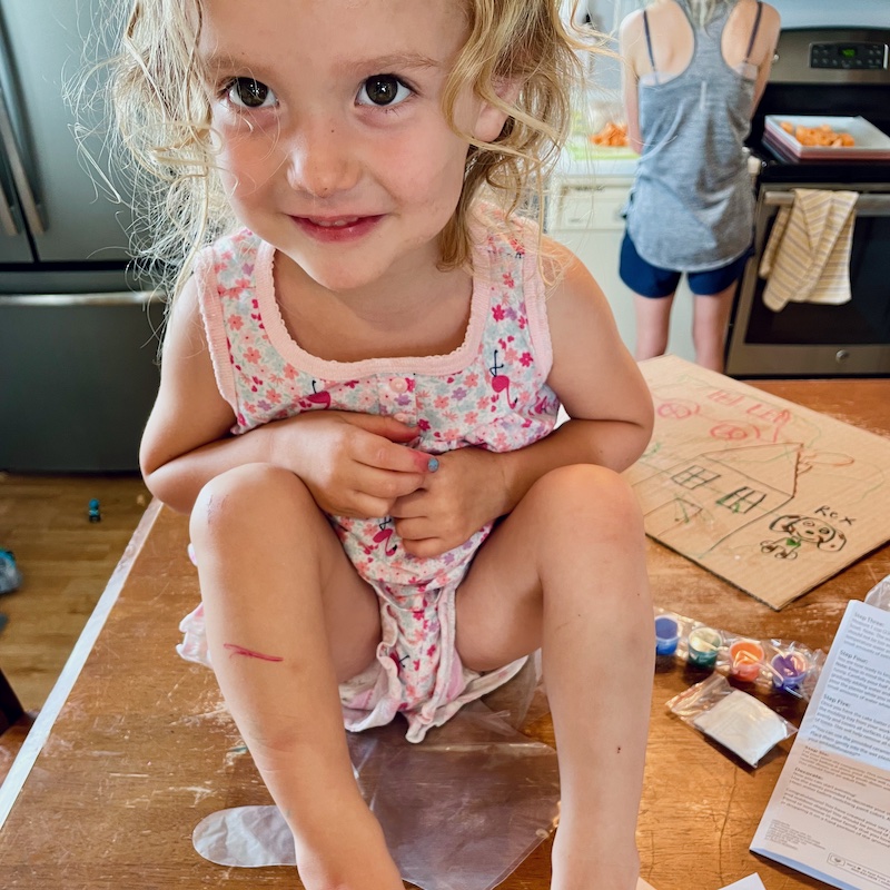 Toddler wearing flamingo pajamas sitting on table and smiling