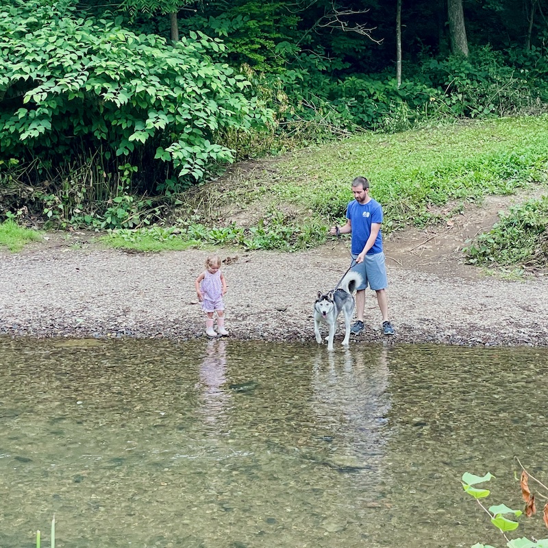 Father and daughter with husky in creek on Panhandle Trail