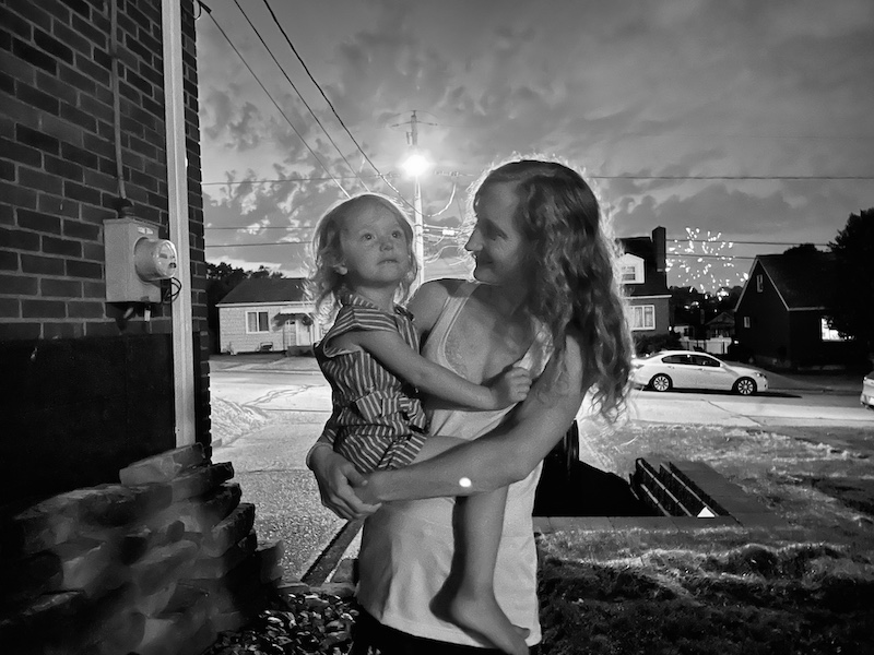 Mom holding toddler during fireworks black and white photo
