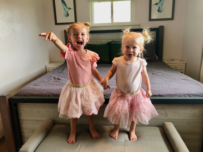 Toddler girls with matching outfits holding hands