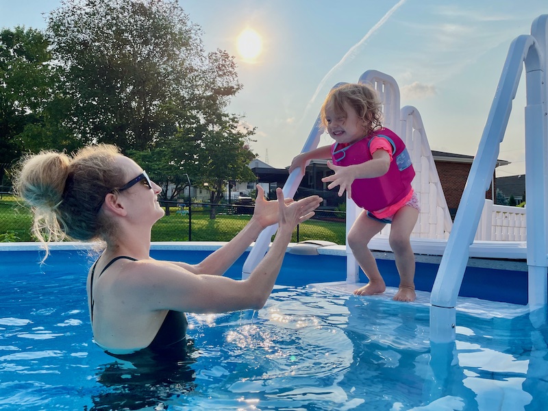 Toddler jumping off ladder and into pool.