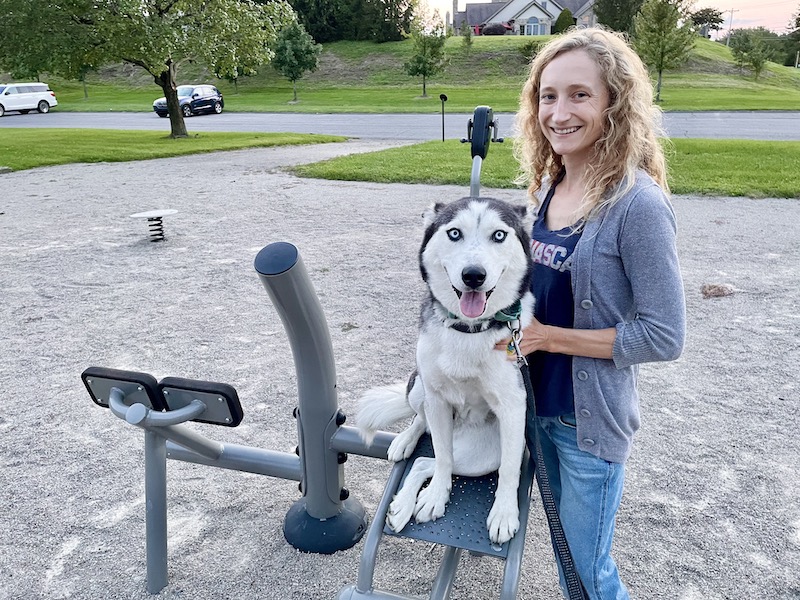 Girl standing with husky at park
