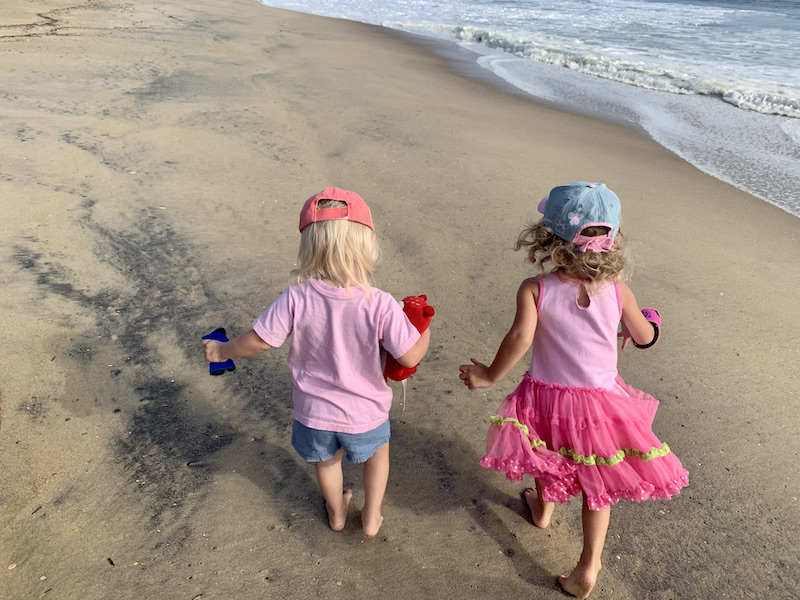 Toddler girls walking on beach in Kill Devil Hills, NC