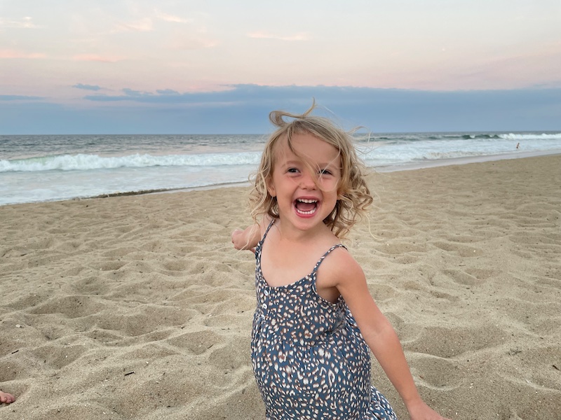 Toddler girl laughing at the beach in Kill Devil Hills, NC