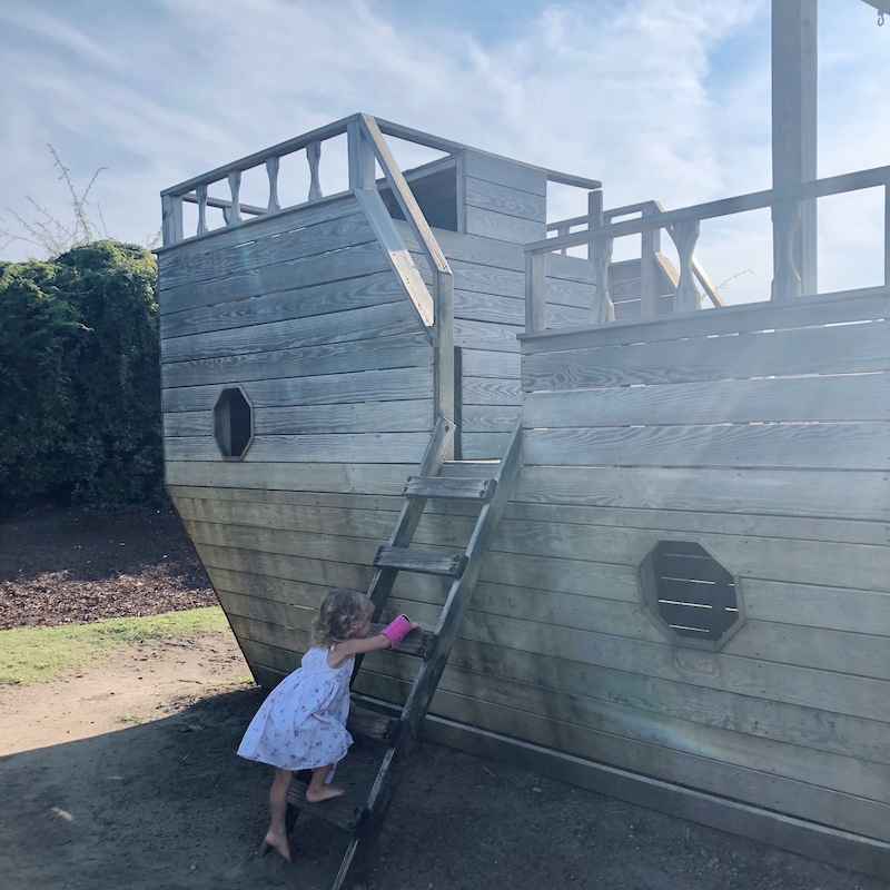 Toddler girl climbing pirate ship at Outer Banks Brewing Station in Outer Banks