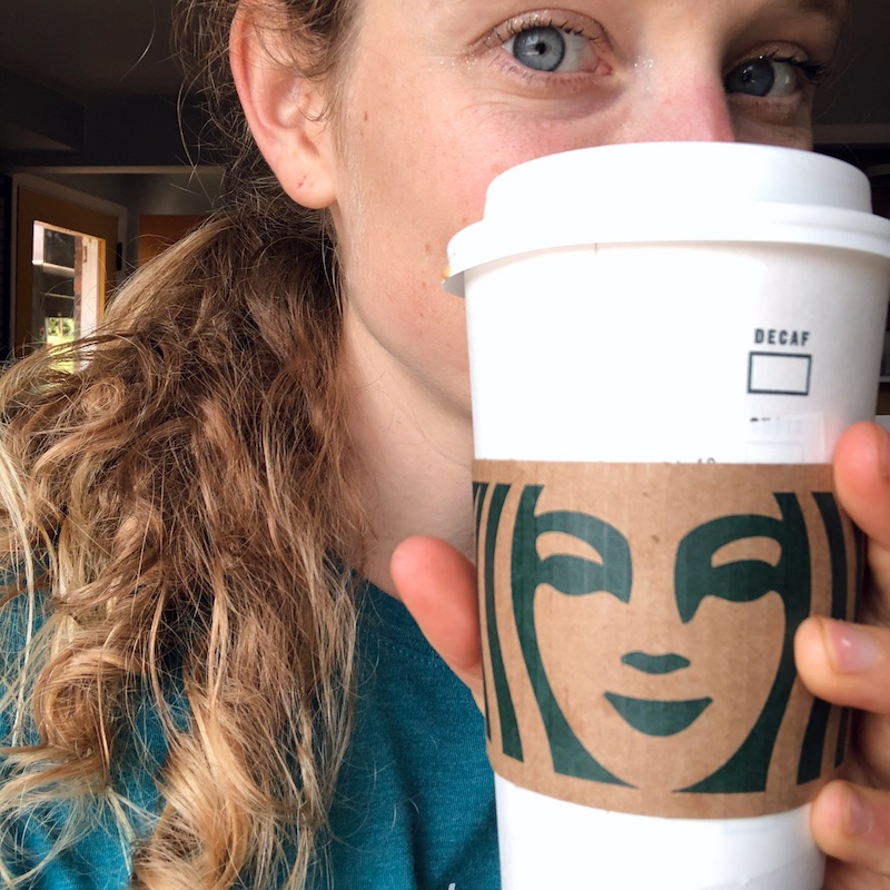 Girl holding Starbucks to go coffee cup