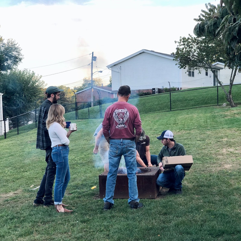 Family standing around bonfire in yard