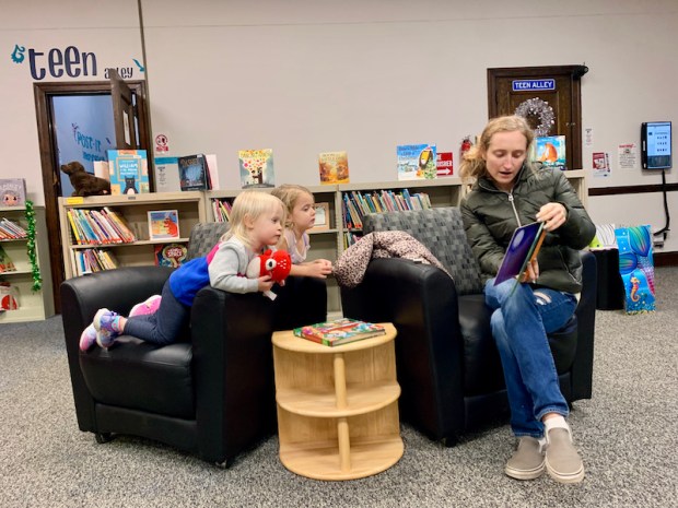 Mom reading to toddlers at the library