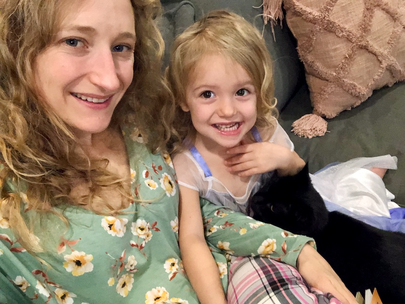 Black cat sitting on toddler's lap