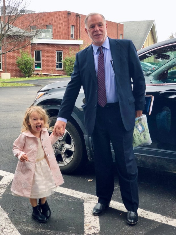 Grandpa holding granddaughter's hand at church