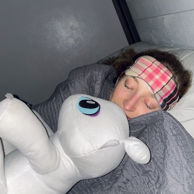 Girl sleeping with stuffed white dragon from How to Train Your Dragon